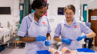Nursing students prepping equipment for a practical session.