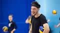 A student laughs while standing with a volleyball tucked under his arm during a MOVE session at the Centre for Sport.