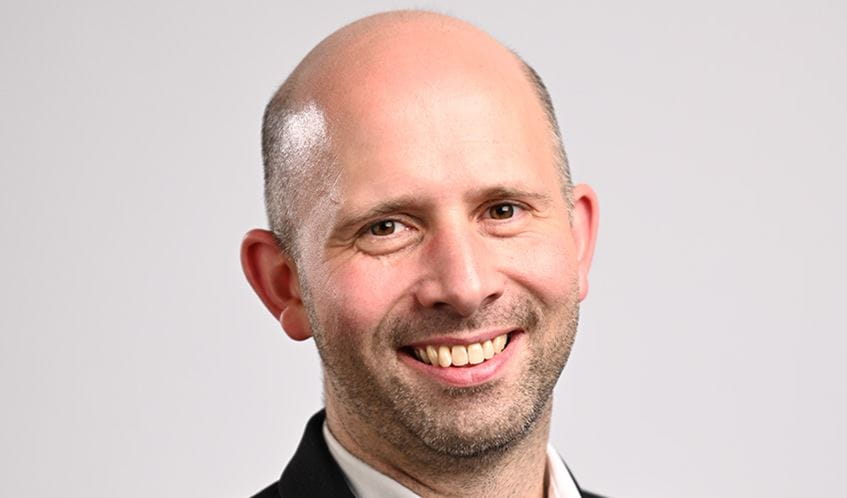 A man smiles at the camera
