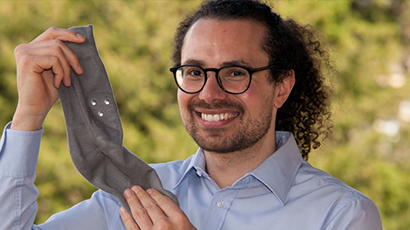 Man holding up a grey sock with inbuilt kinetic sensor just visible.