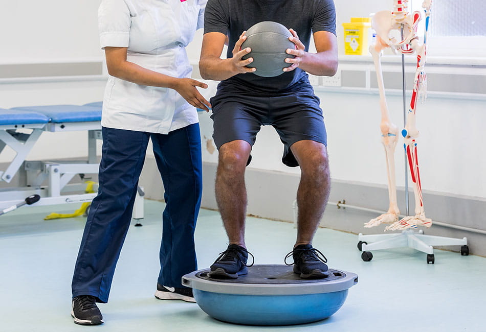 A physiotherapy student supporting a patient with physical exercises.