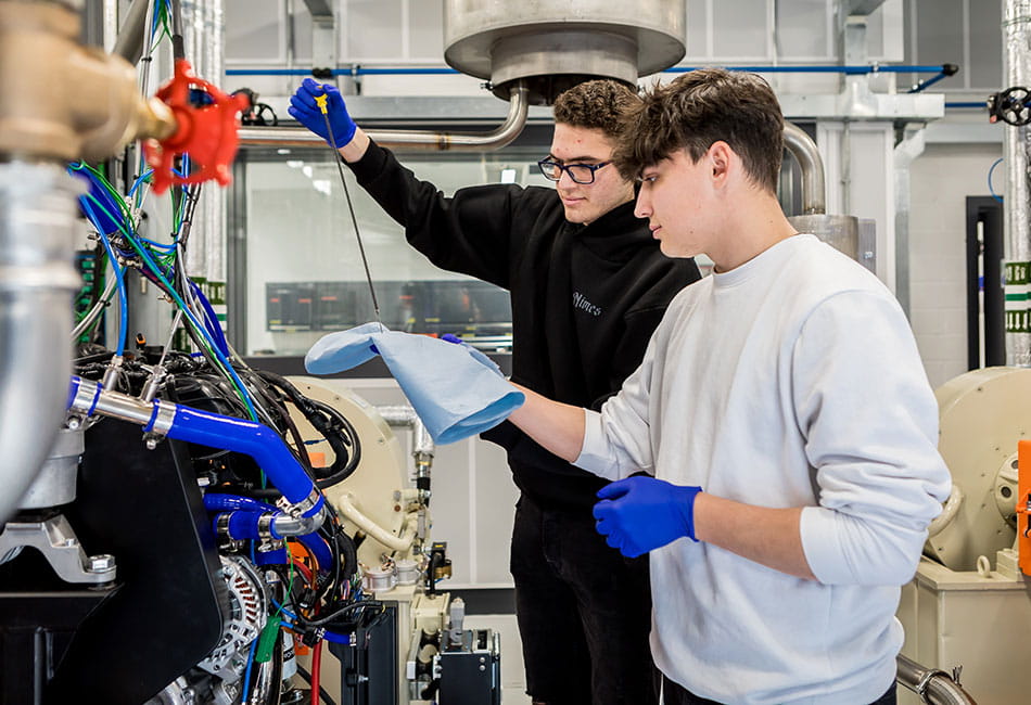 Two students completing tests on a machine.