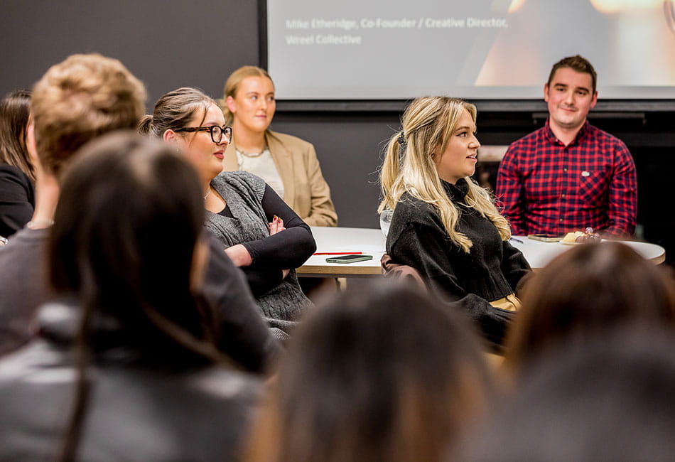 A group of people listening to a talk in a classroom.