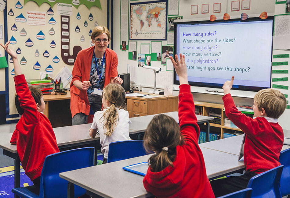 A teacher teaching primary school children in a classroom.