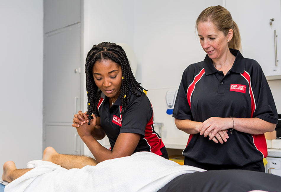 A student massaging a patient under the guidance of a lecturer.