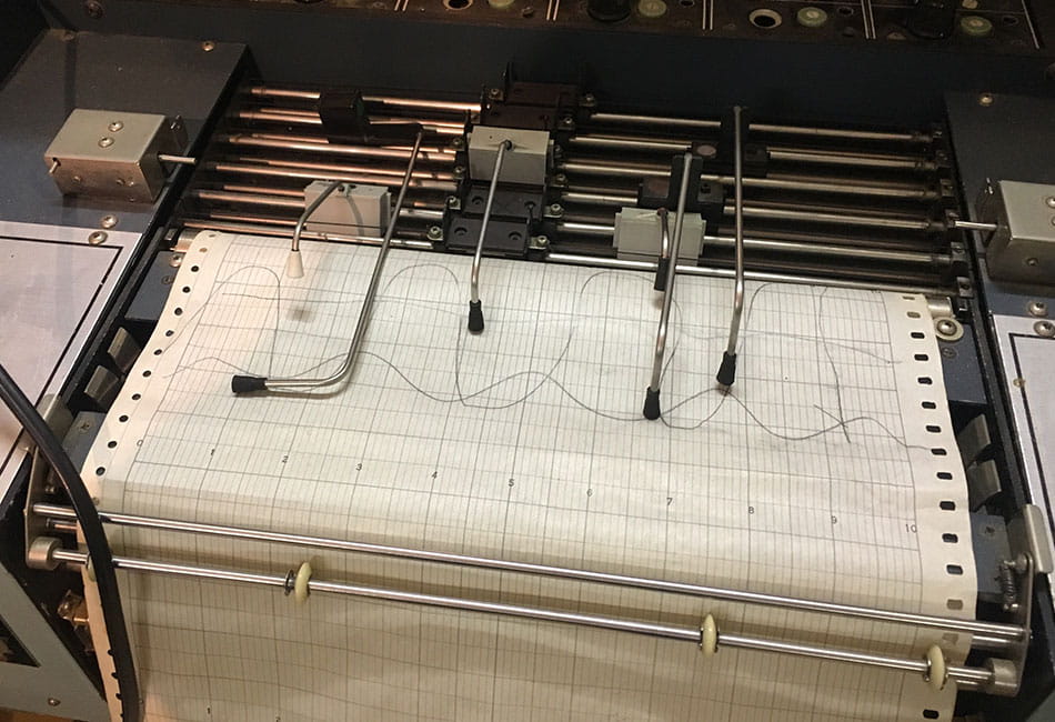 A polygraph machine drawing test results on paper.