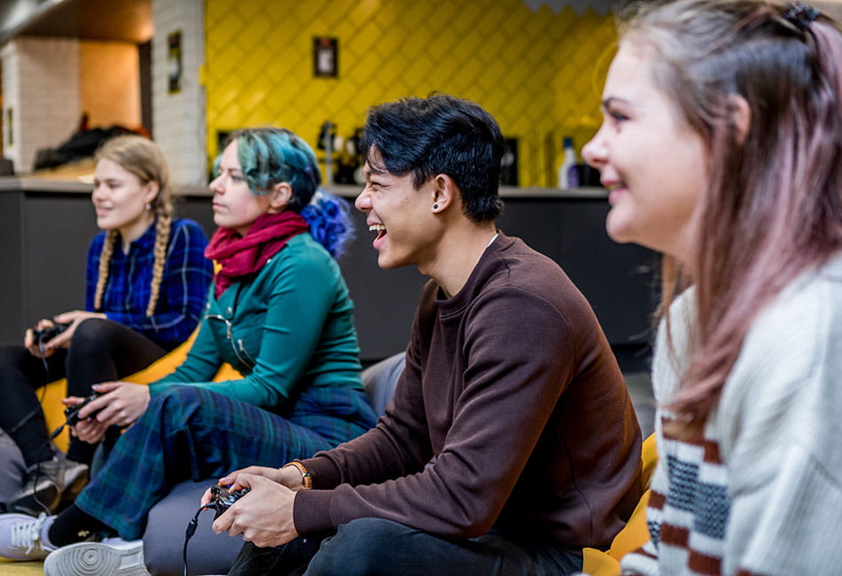 A group of four students playing video games.