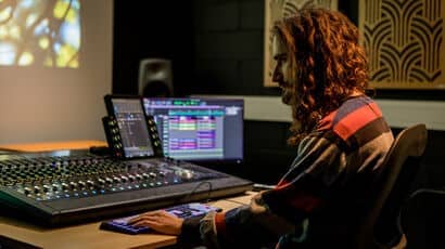 A man sitting at a mixing desk and computer screen. © Tom Sparey, All Rights Reserved.