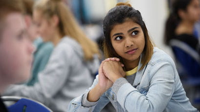 Girl with hands together looking thoughtfully