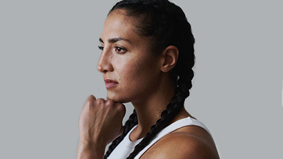 Woman with braided hair in profile, resting her chin on her fist.
