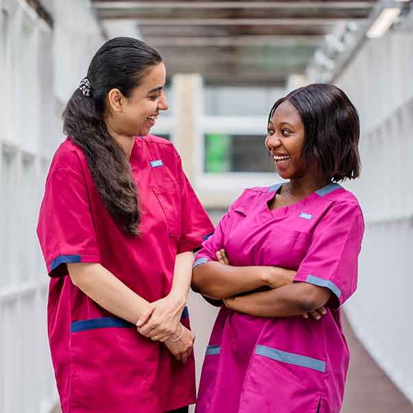 Health and social care students smiling at each other