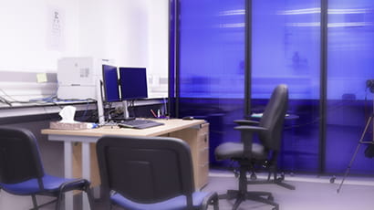 A consultation area containing chairs and a desk with a computer.