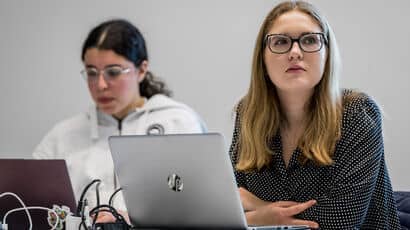Two female students working at laptops.