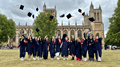 International Summer School students in graduation robes, tossing their graduation caps into the air, on College Green in Bristol.