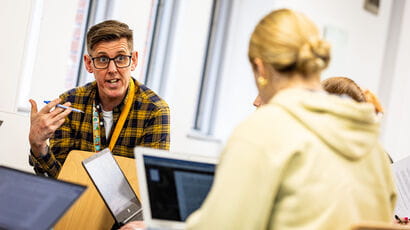 Lecturer in conversation with a student during class.