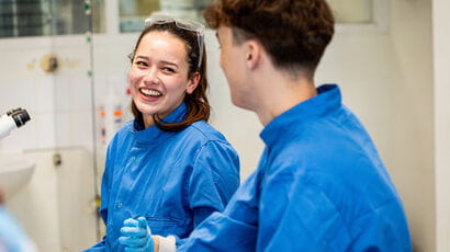 Two biomedical students in a lab laughing together.