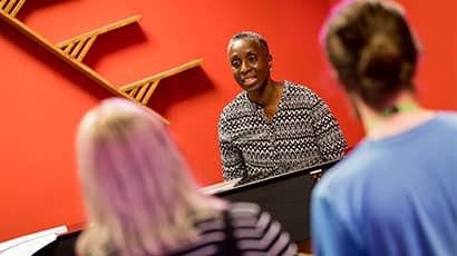 Singing coach leading a vocal lesson with a group.