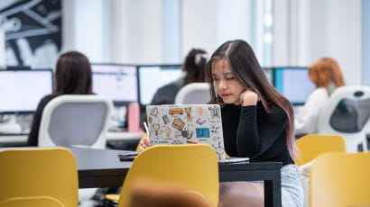 Student working in a study lounge on a laptop