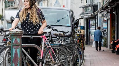 A woman taking her bike on the street