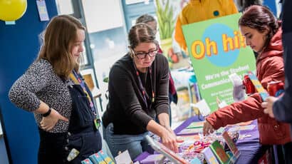 New students at welcome event talking to the Student Communications Team at their stall.