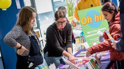 New students at welcome event talking to the Student Communications Team at their stall.