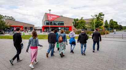 Group of people on a tour of Frenchay Campus walking by the Students' Union building.