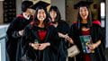 A group of graduates in robes smiling.