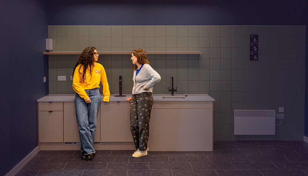 Two students chatting in a communal kitchen at Purdown View accommodation