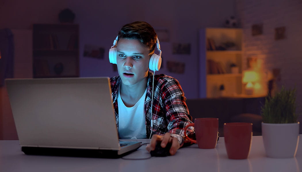 Student with headphones at a laptop