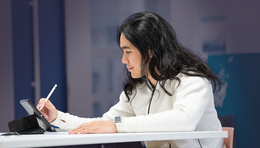 Student using stylus pen on a tablet device