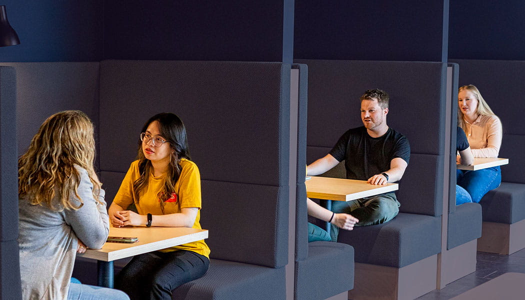 Students chatting in seating booths