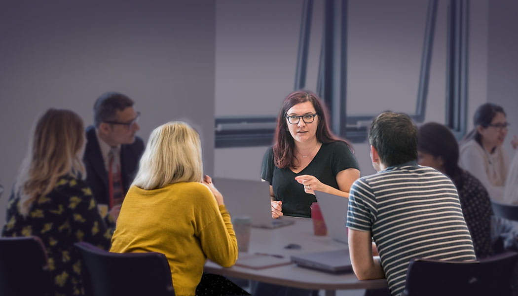 Continual Professional Development programme with people in discussion, sat around a table