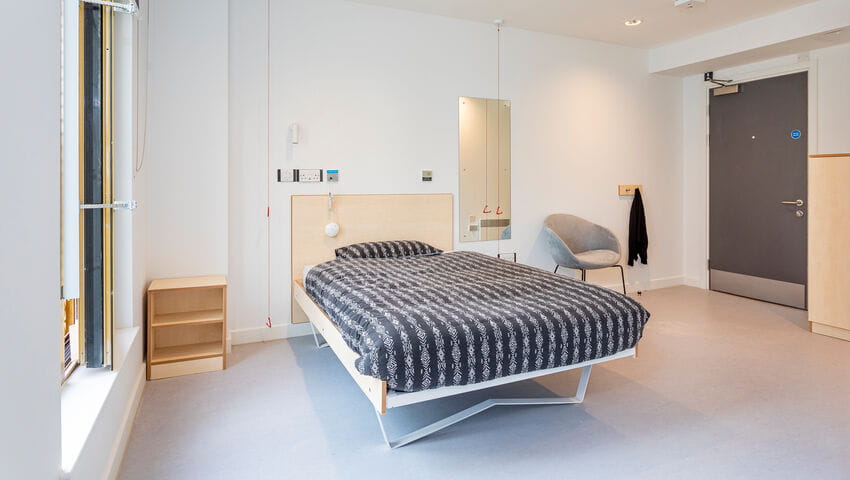 An adapted room in Purdown View accommodation, including a bed with adjustable height, wide doorways, spacious floor plan and red emergency cord.