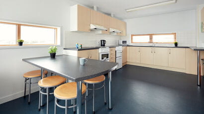 A shared kitchen in the Student Village, fully equipped with a communal seating area.