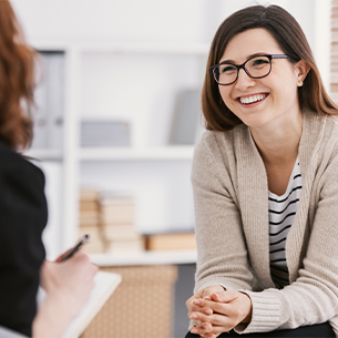 Counsellor talking to a client with a smile.