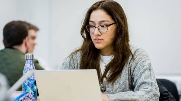 Student focussing on her laptop.