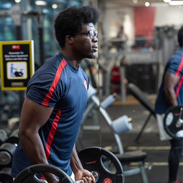 Man training with free weights in the UWE Bristol gym.