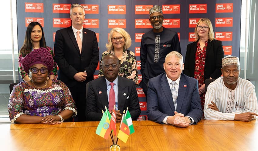 A group of people stood in front of a UWE Bristol branded banner in two rows