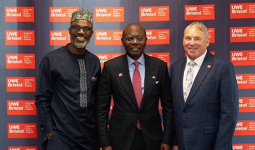 Three men stood in front of a branded banner for UWE Bristol.