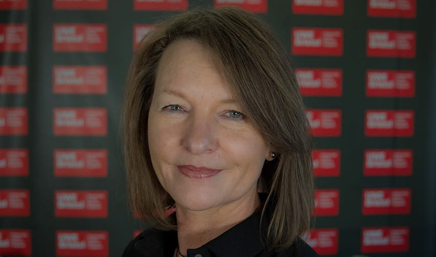 A woman with brown bobbed hair smiles at the camera.