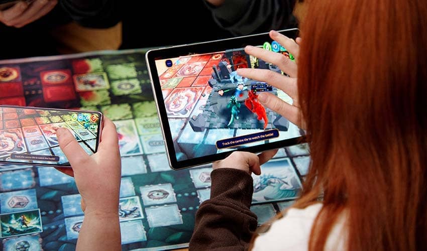 Woman playing an augmented reality board game using a tablet computer