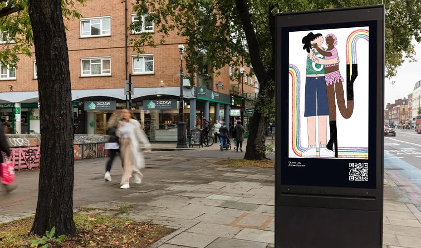 A street in Bristol shows people walking past a marketing board with a piece of eye catching artwork.