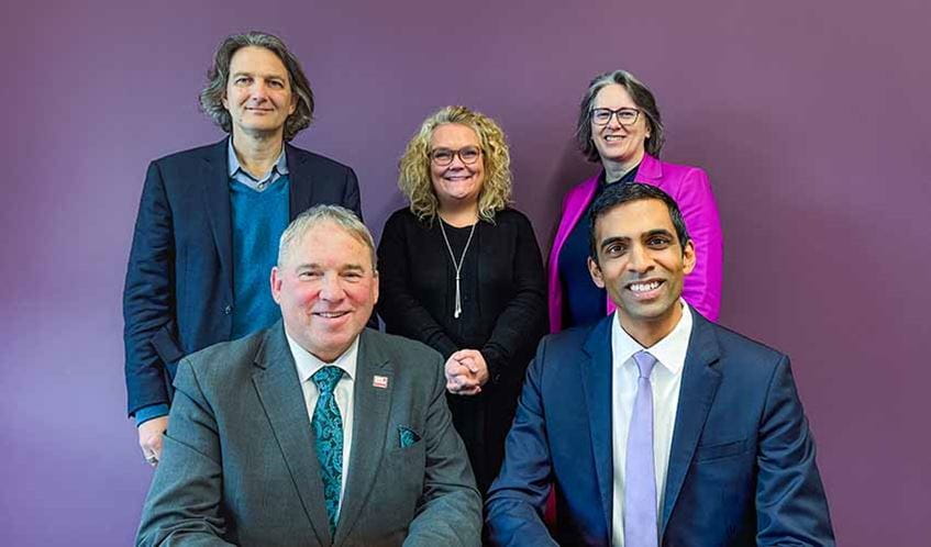 Group photo of five people with a purple background, Back: Paul Smith (Chief Revenue Officer, Skilled Education), Jo Midgley (Registrar & Deputy Vice-Chancellor, UWE Bristol), Joanne Roxburgh (Chief Operating Officer, Skilled Education); Front: Professor Sir Steve West (Vice-Chancellor and President, UWE Bristol), Rajay Naik (Chief Executive Officer, Skilled Education).