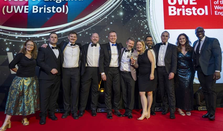 A group of people standing on a stage smiling. 