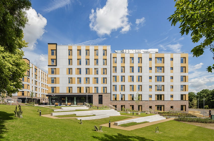 A large block of student accommodation flats with a grass area in the foreground