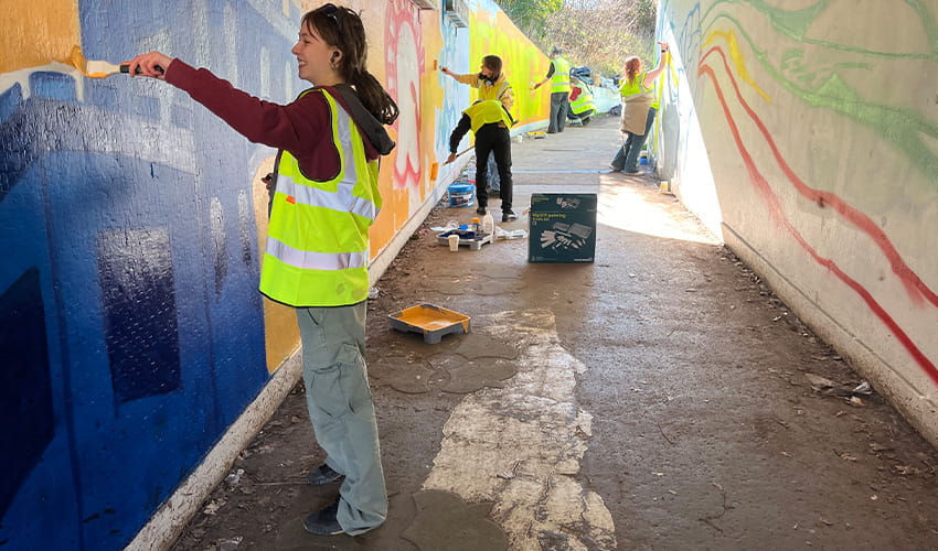 An underpass gets a makeover with a group of students painting a colourful mural.