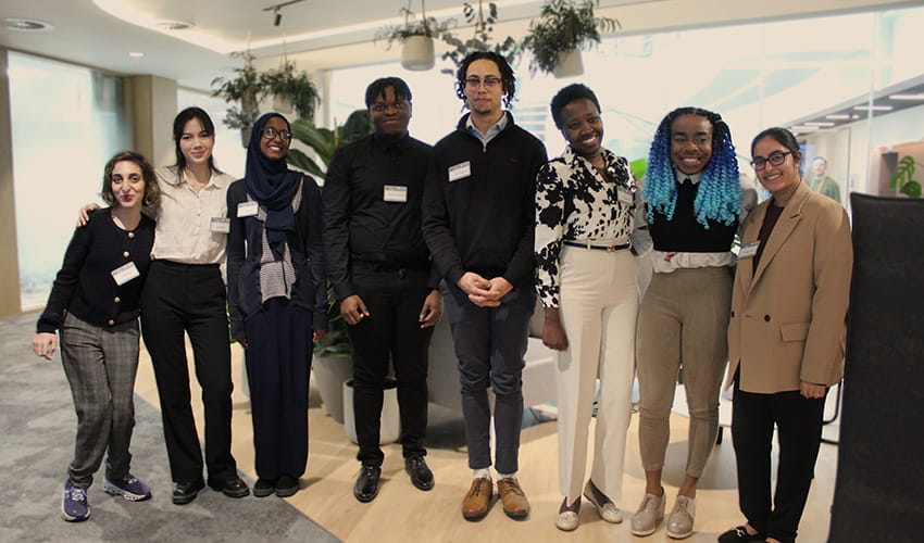 A group of young professionals gathered in a corporate office setting 