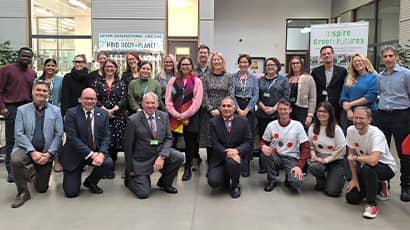 A large group of people gathered looking at the camera, with some crouched at the front. 