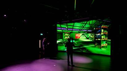 A person performing in front of a large projected image