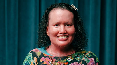 Headshot of Carly Findlay OAM against a teal background.